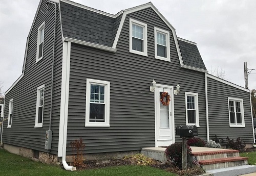 A two-story house with gray siding and white trim. 