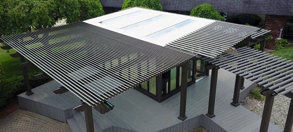 Three pergolas position to create a single outdoor living area in a backyard. 