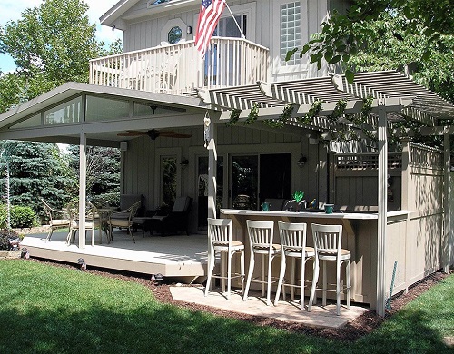 A house with a large covered patio and attached pergola. 